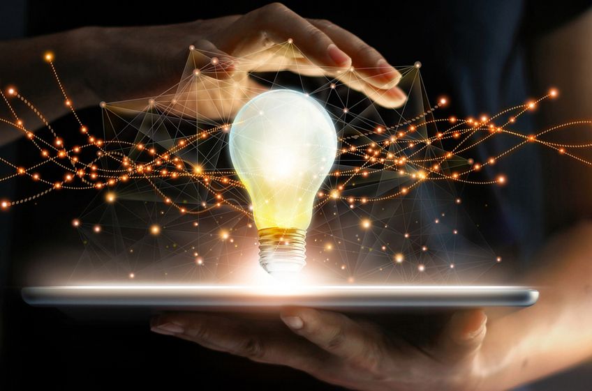 istock.com/ipopba Glühbirne auf Tablett mit Hand darüber