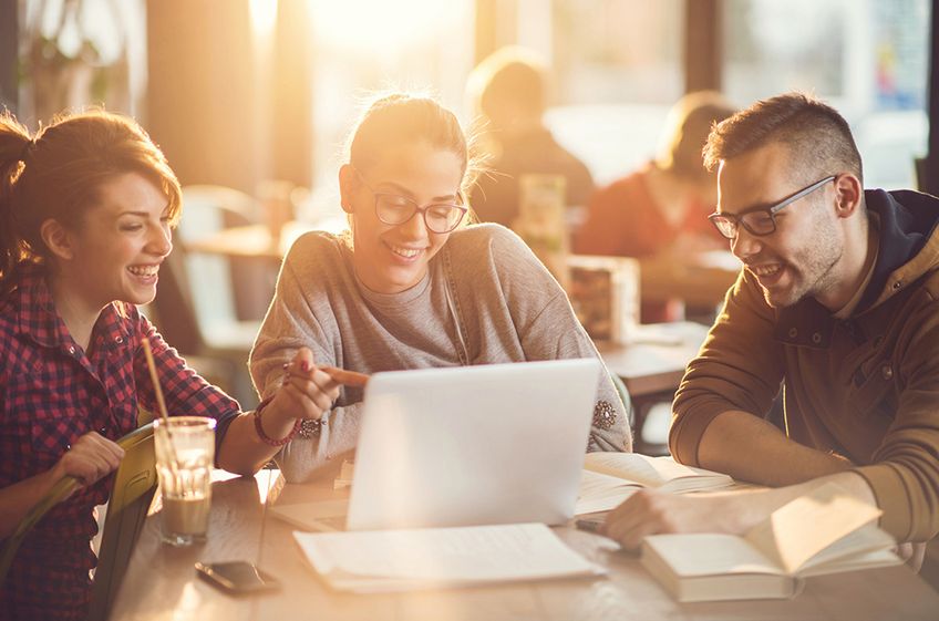 istock.com Drei junge Menschen vor Laptop, junge Frau vor Laptop, zwei junge Menschen vor Laptop